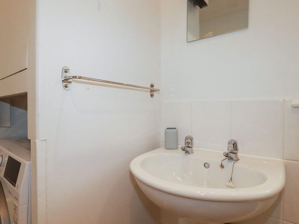 A bathroom with a sink and mirror at Honeysuckle Cottage in Charlestown