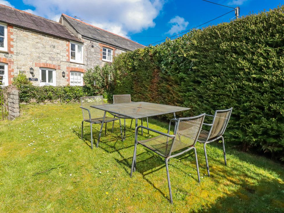 A garden with a table and chairs at Honeysuckle Cottage in Charlestown