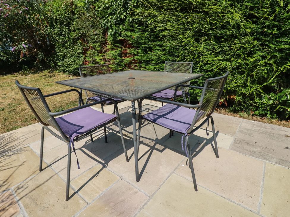 A table and chairs in a garden at Honeysuckle Cottage in Charlestown