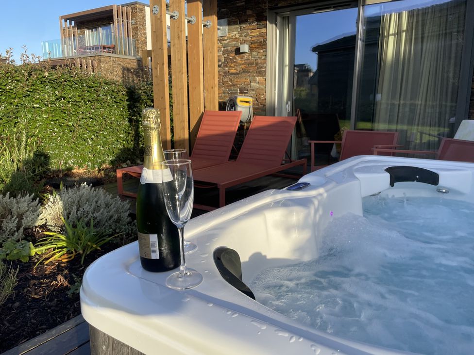 An outdoor area with a hot tub and champagne at Villa 80 in Carbis Bay