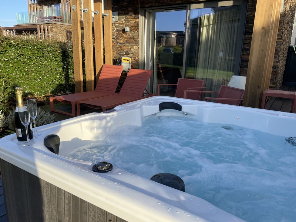 An outdoor area with a hot tub and two chairs at Villa 80 in Carbis Bay