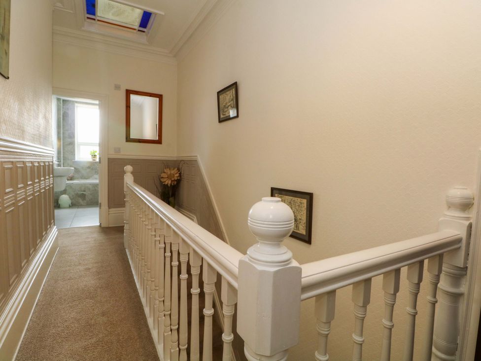 A hallway with stair railing and a door to the bathroom at 163 Manchester Road in Accrington