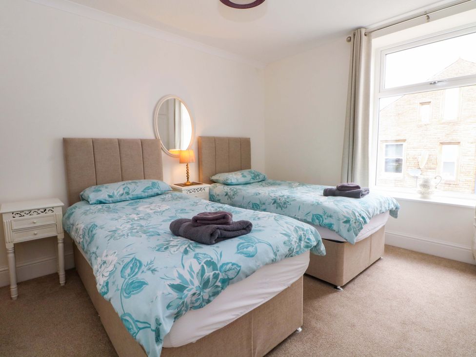 A bedroom with two single beds and a mirror at 163 Manchester Road in Accrington