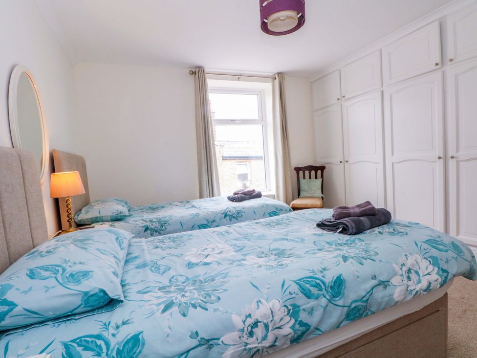 A bedroom with two beds and a wardrobe at 163 Manchester Road in Accrington
