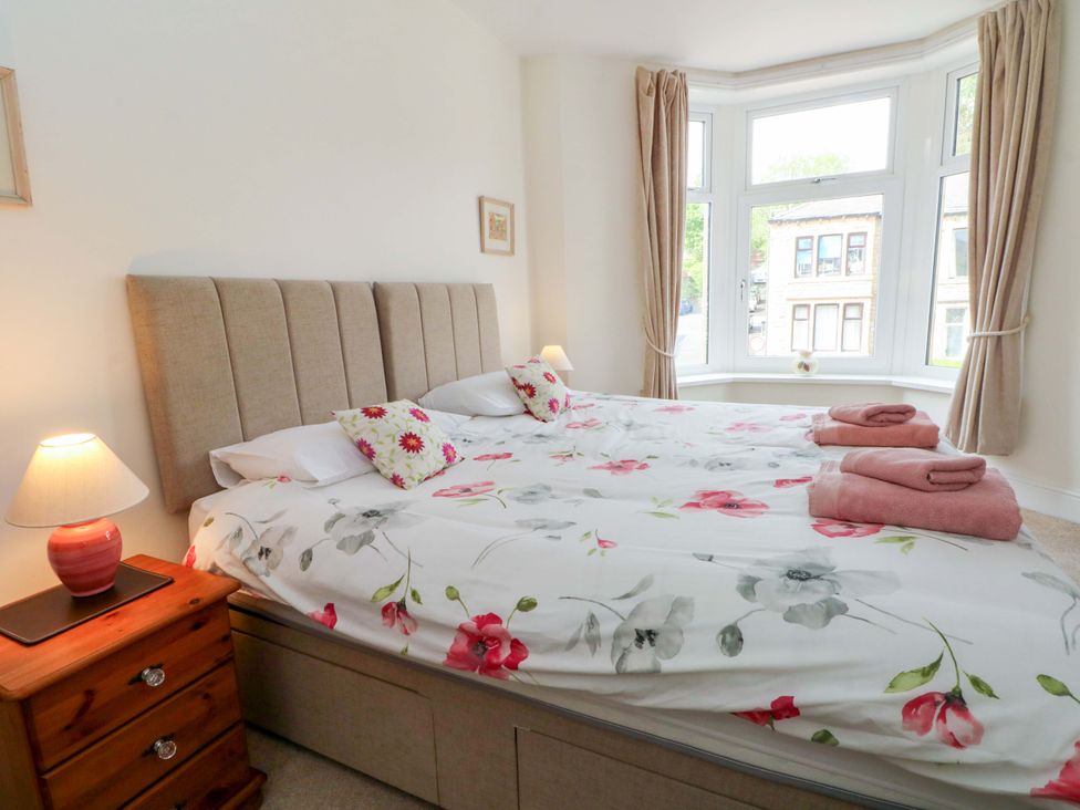A bedroom with a large bed and a bedside table at 163 Manchester Road in Accrington