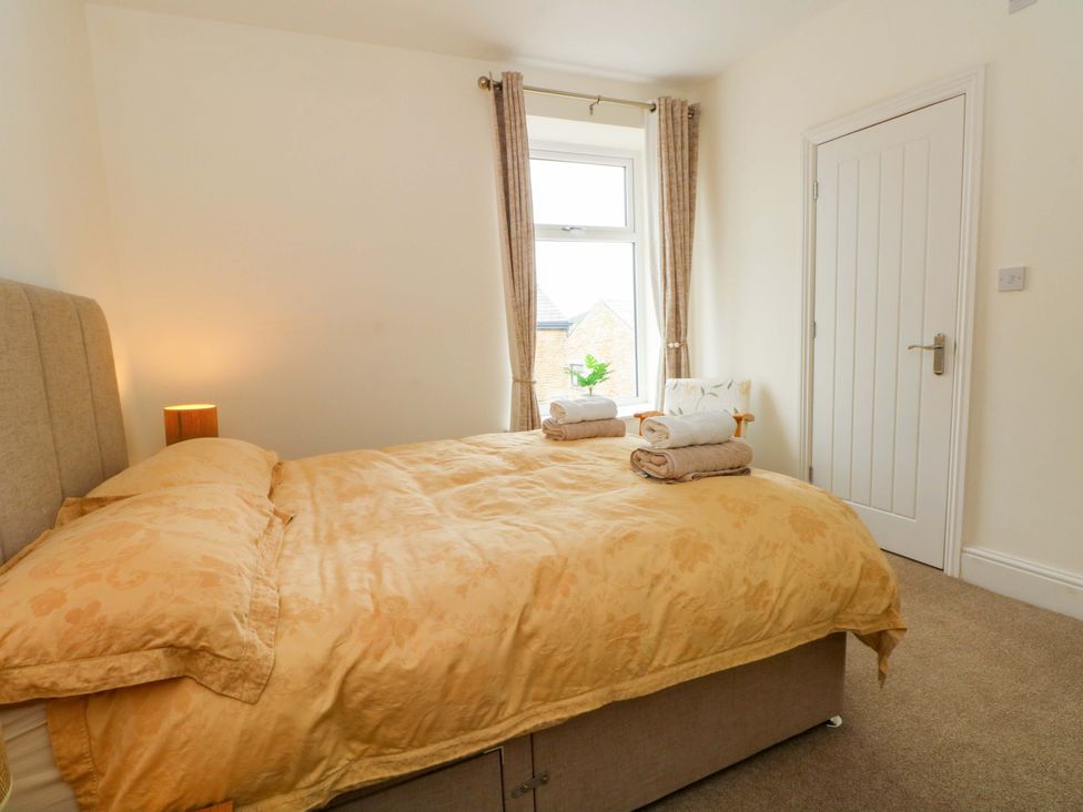 A bedroom with a bed and towels arranged at 163 Manchester Road Accrington