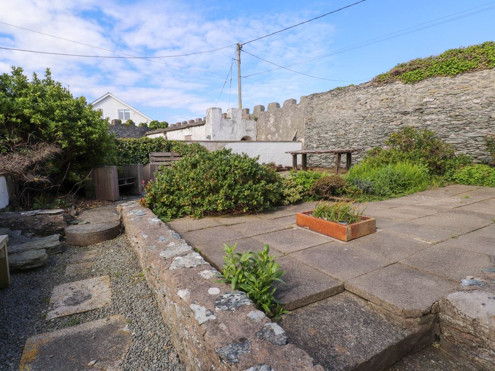 A garden area with stone walls plants and a paved patio at Flat 3 in Trearddur Bay