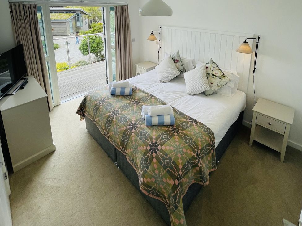 A bedroom with a bed and sliding door at Una, Lodge 73, Carbis Bay