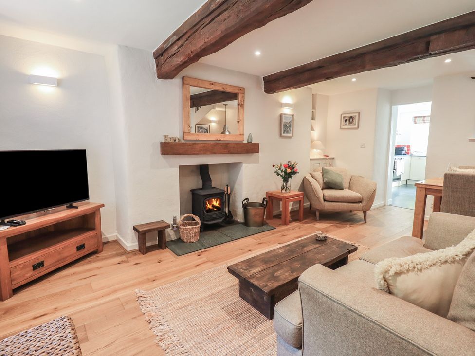 A living room with a fireplace and television at Daffodils in Ambleside