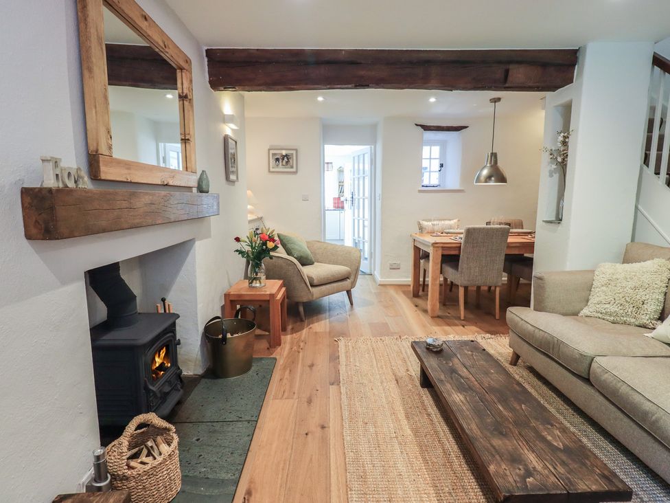 A living room with a fireplace and dining area at Daffodils in Ambleside