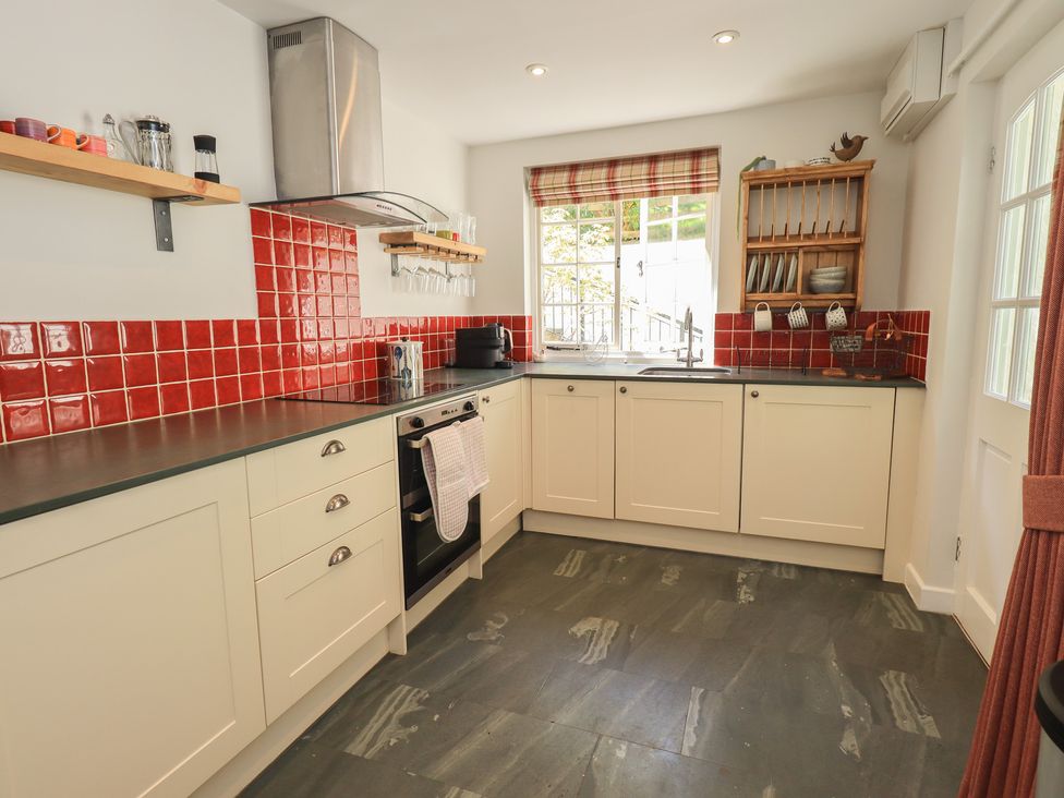 A kitchen with red tiles and appliances at Daffodils in Ambleside