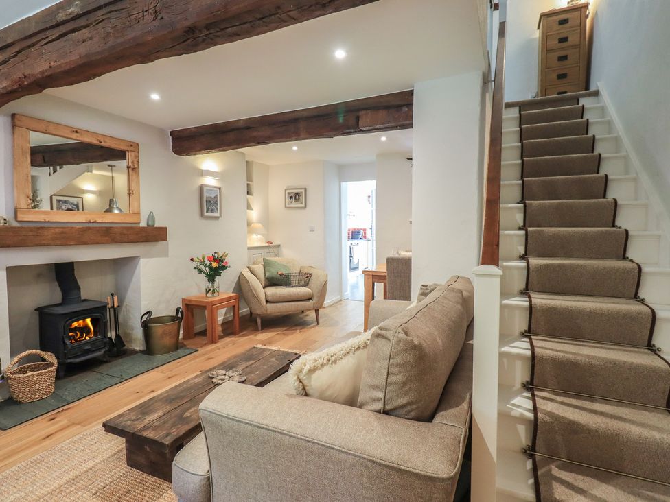 A living room with a sofa, coffee table, and fireplace at Daffodils in Ambleside
