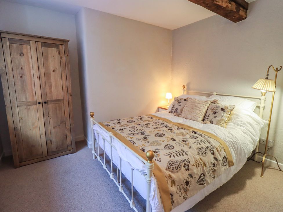 A bedroom with a bed and wardrobe at Daffodils in Ambleside