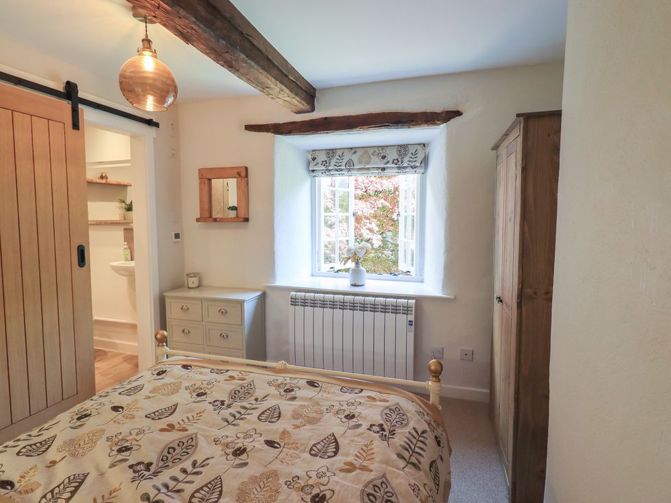 A bedroom with a bed and wardrobe at Daffodils in Ambleside