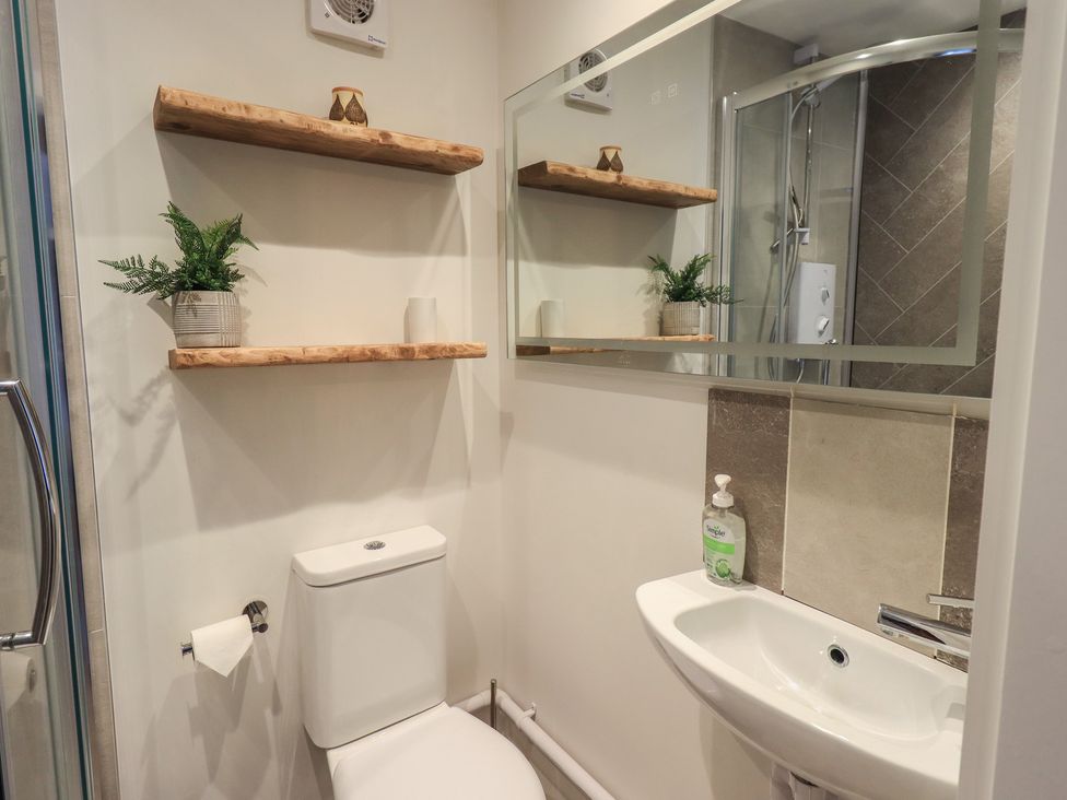 A bathroom with a toilet, sink, and shower at Daffodils in Ambleside