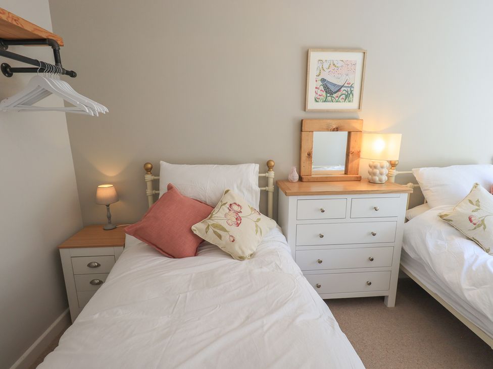 A bedroom with two beds and a chest of drawers at Daffodils in Ambleside