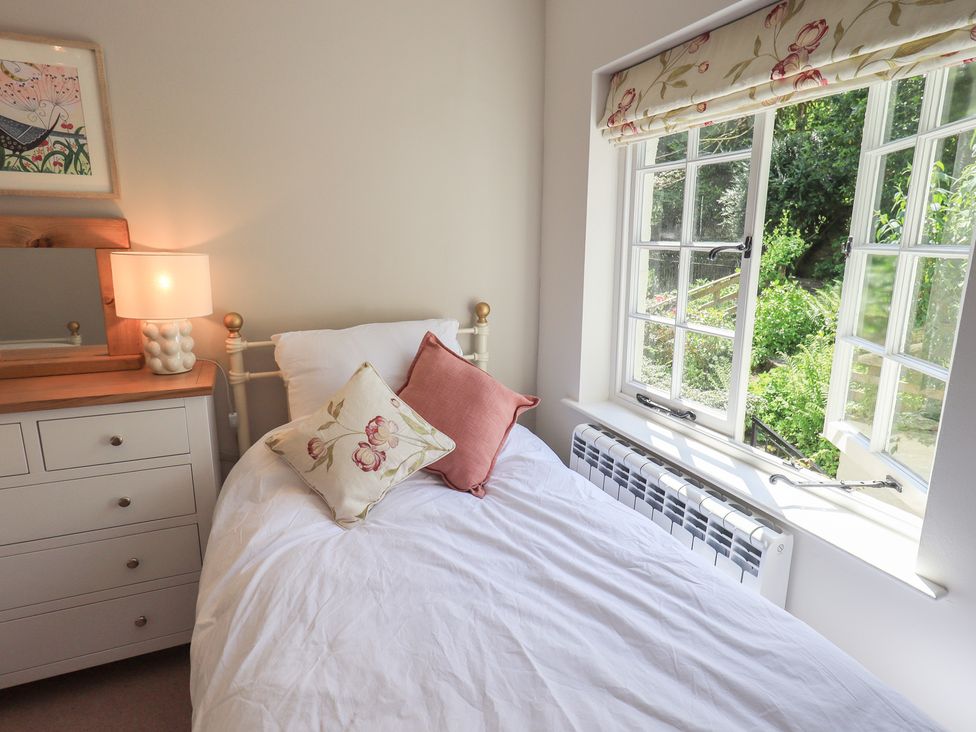 A bedroom with a bed and lamp at Daffodils in Ambleside