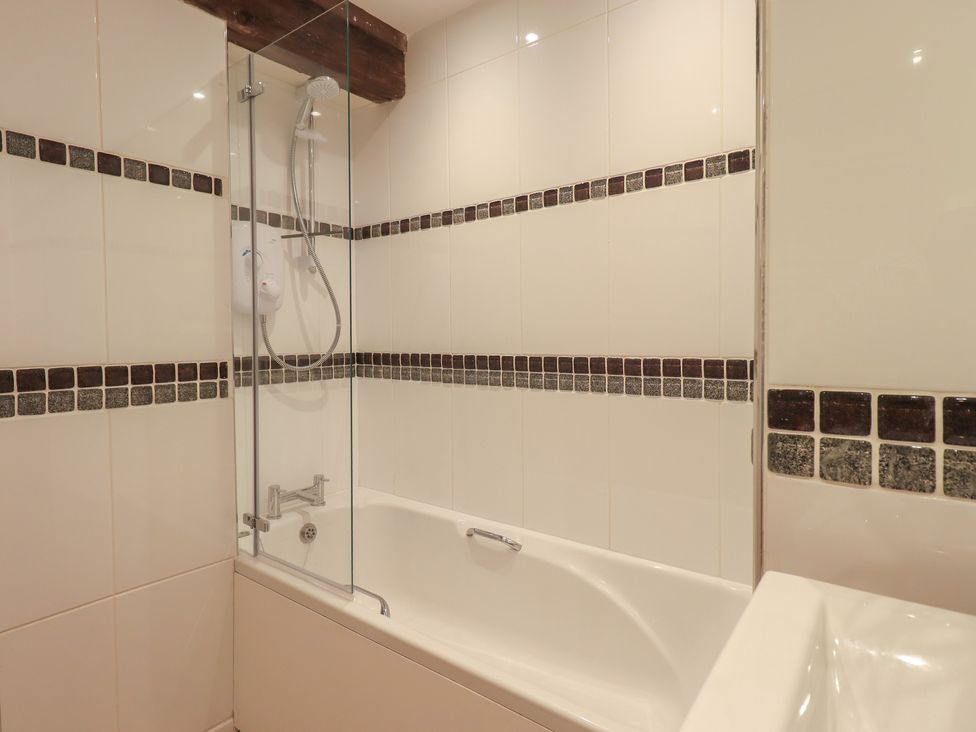 A bathroom with a bathtub and shower at Daffodils in Ambleside