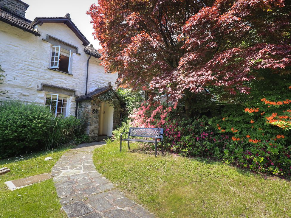 A garden with a pathway and a bench at Daffodils in Ambleside