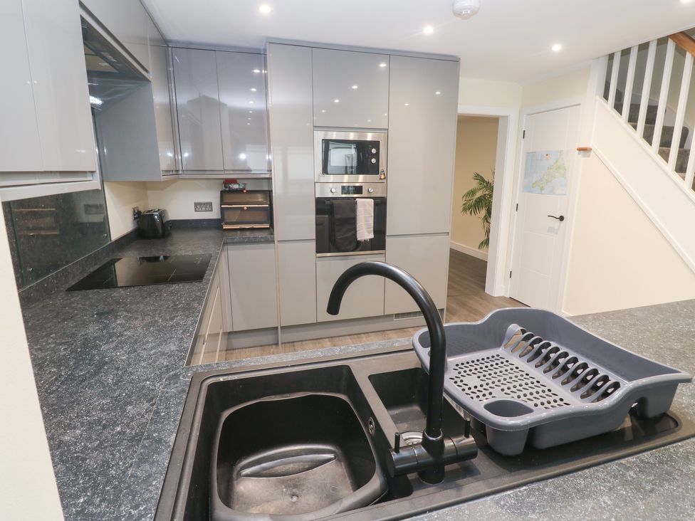 A kitchen with a sink and dish rack at Boslowen in Portreath