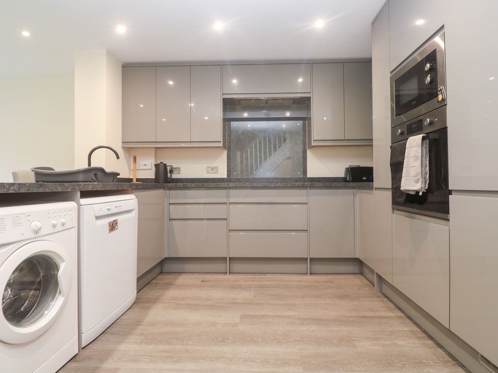 A kitchen with appliances and cabinets at Boslowen in Portreath