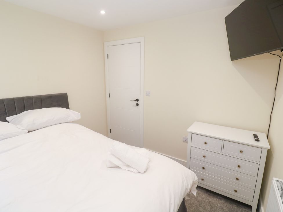 A bedroom with a bed, drawer unit and TV at Boslowen in Portreath