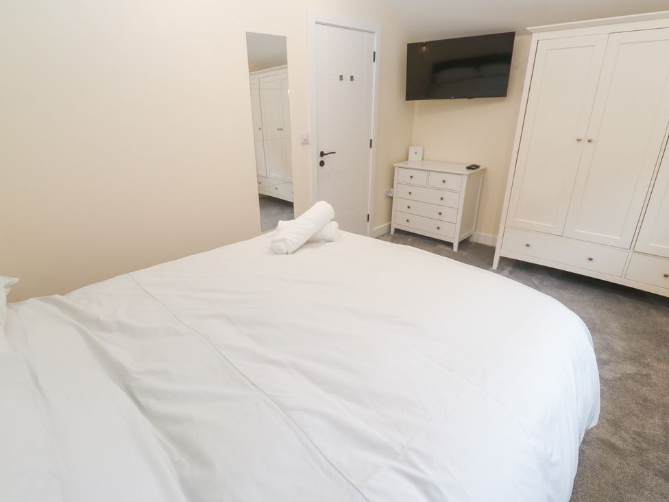 A bedroom with a bed and wardrobe at Boslowen in Portreath