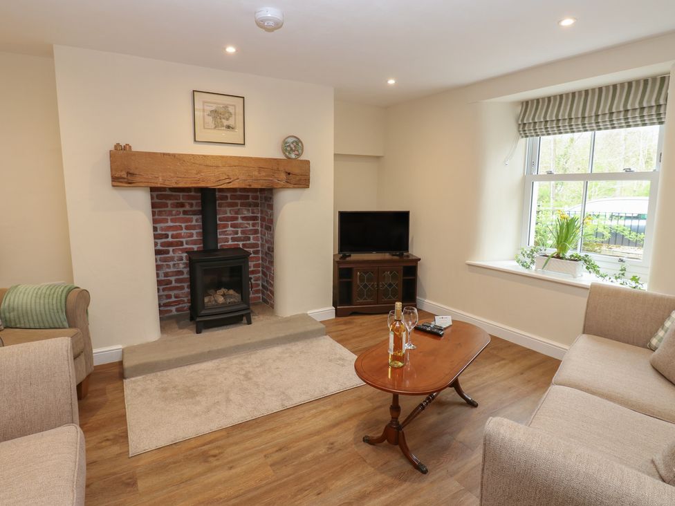 A living room with a fireplace and sofa at 1 Brookside in Warcop