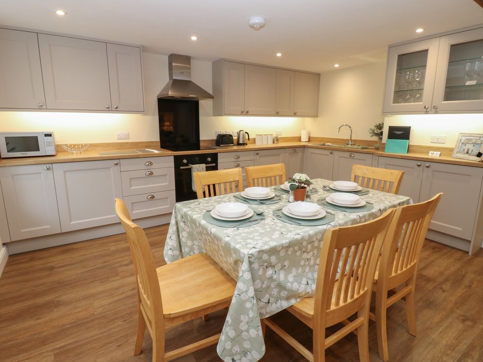 A kitchen with a dining table and chairs at 1 Brookside in Warcop