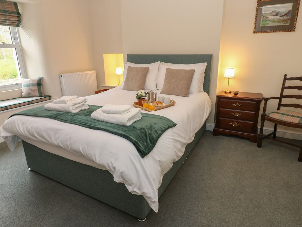 A bedroom with a bed, table, and chair at 1 Brookside in Warcop