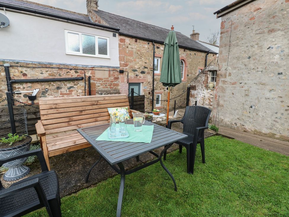 A garden with a table and chairs at 1 Brookside Warcop