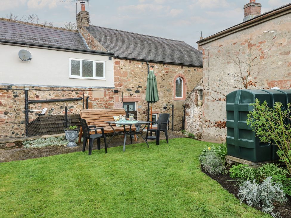 A garden with a table and chairs at 1 Brookside in Warcop