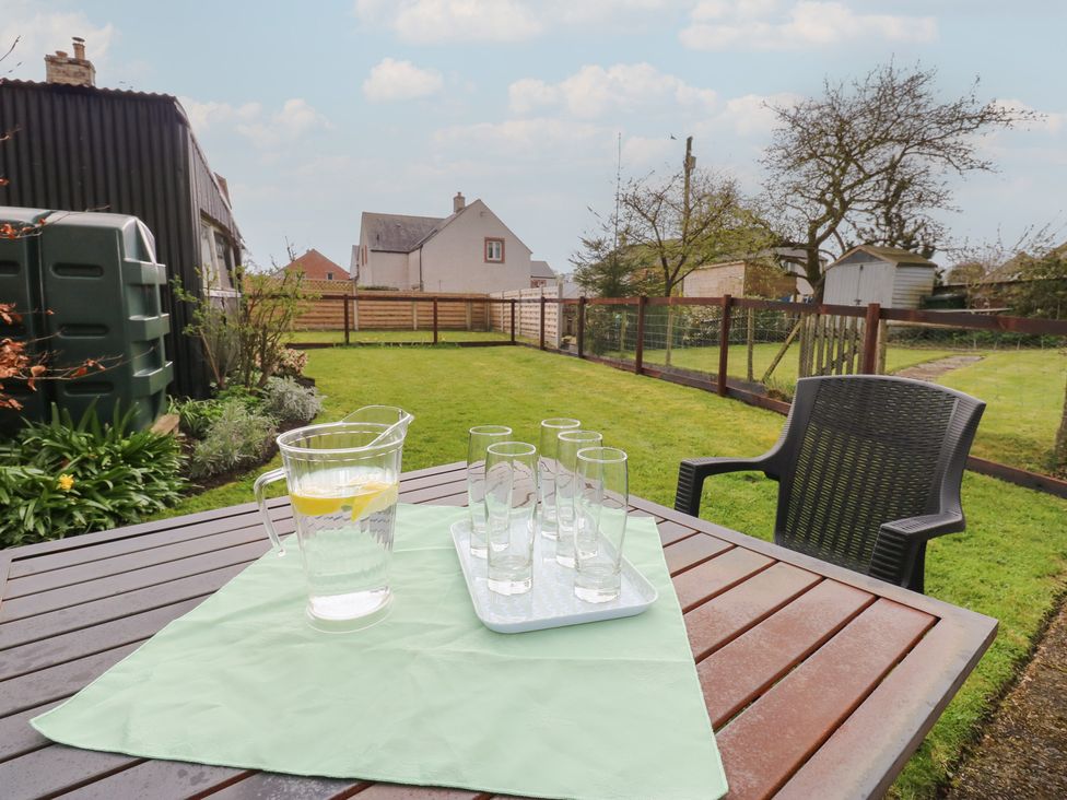 A table with a pitcher and glasses in a garden at 1 Brookside Warcop