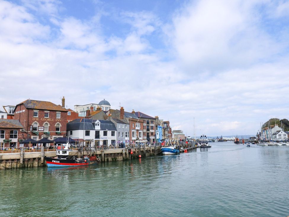 A harbor with boats and buildings at Apartment 1 Brewers Quay in Weymouth