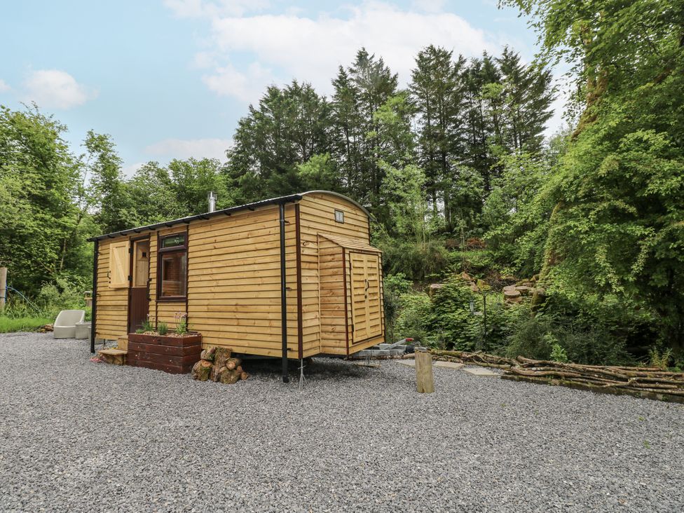 A tiny house with wood exterior and gravel surface at The Hamper in Felingwm near Carmarthen