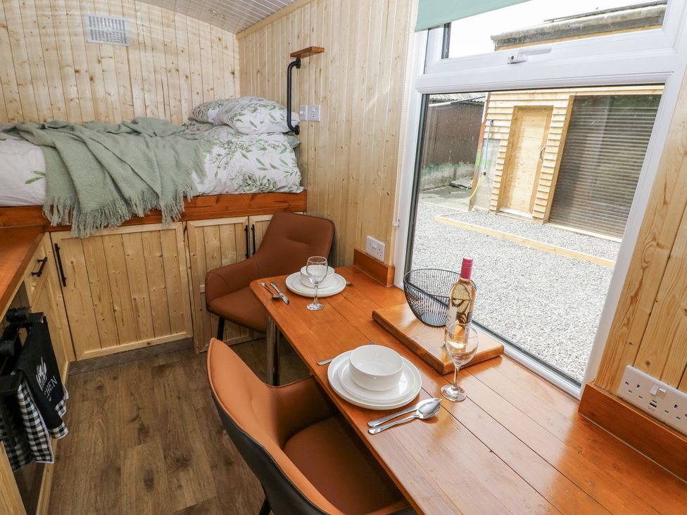 A bedroom with a bed and dining area at The Hamper in Felingwm near Carmarthen