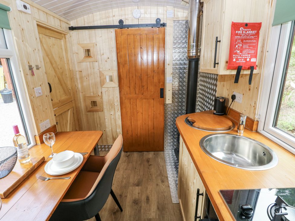 A kitchen with a table and cooking facilities at The Hamper in Felingwm near Carmarthen