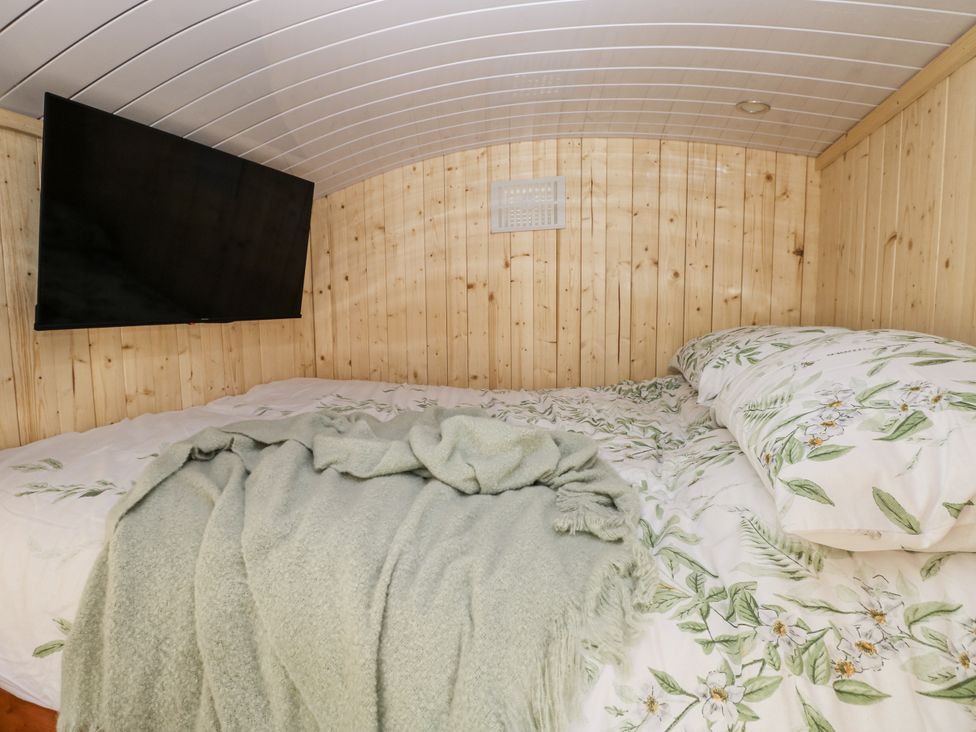 A bedroom with a bed and a television at The Hamper in Felingwm near Carmarthen