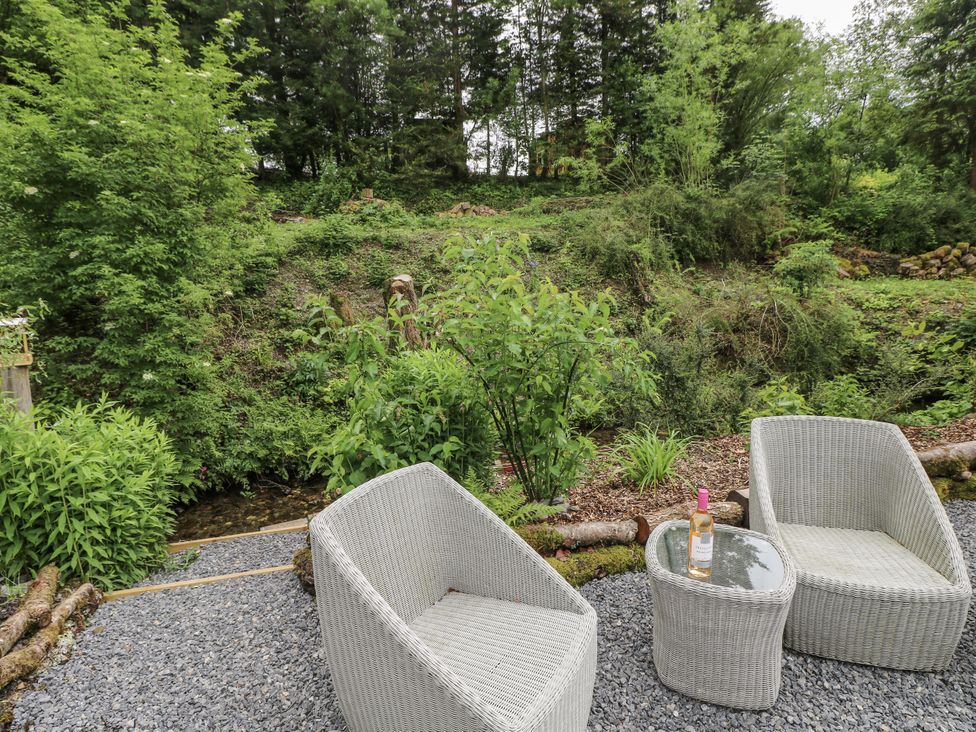 A garden with two chairs and a table at The Hamper in Felingwm near Carmarthen