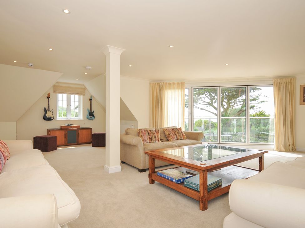 A living room with a coffee table and guitars at Bodare 8 in Daymer Bay