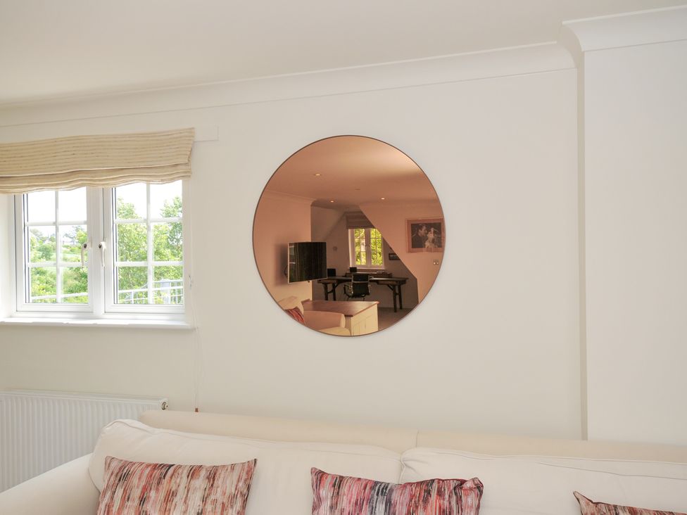 A living room with a mirror and window at Bodare 8 Daymer Bay