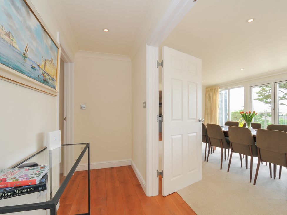 A hallway leading to a dining room with a table and chairs at Bodare 8 in Daymer Bay