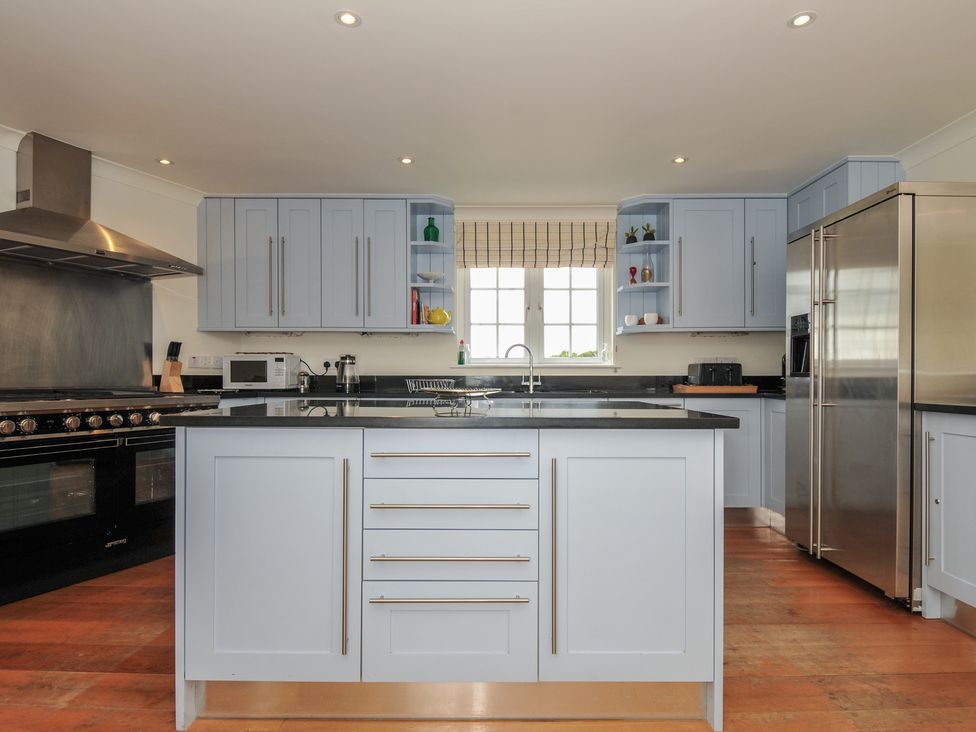 A kitchen with a central island and appliances at Bodare 8 Daymer Bay