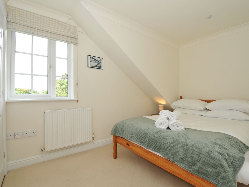A bedroom with a bed and towels at Bodare 8 in Daymer Bay