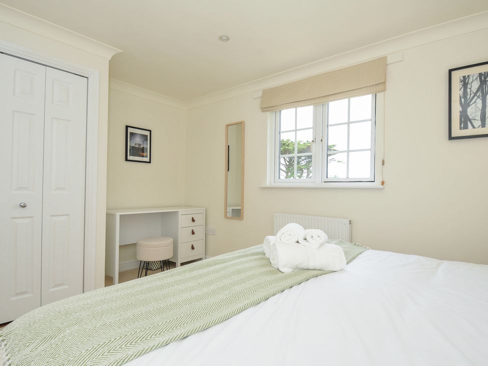 A bedroom with a bed and desk at Bodare 8 in Daymer Bay