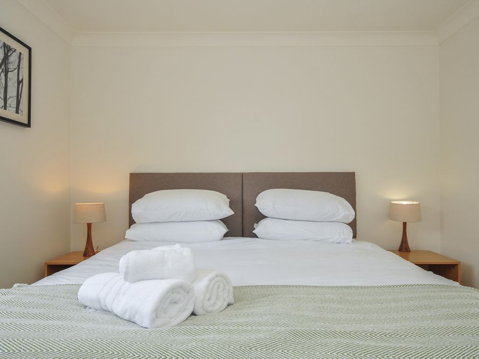 A bedroom with a bed and towels at Bodare 8 in Daymer Bay