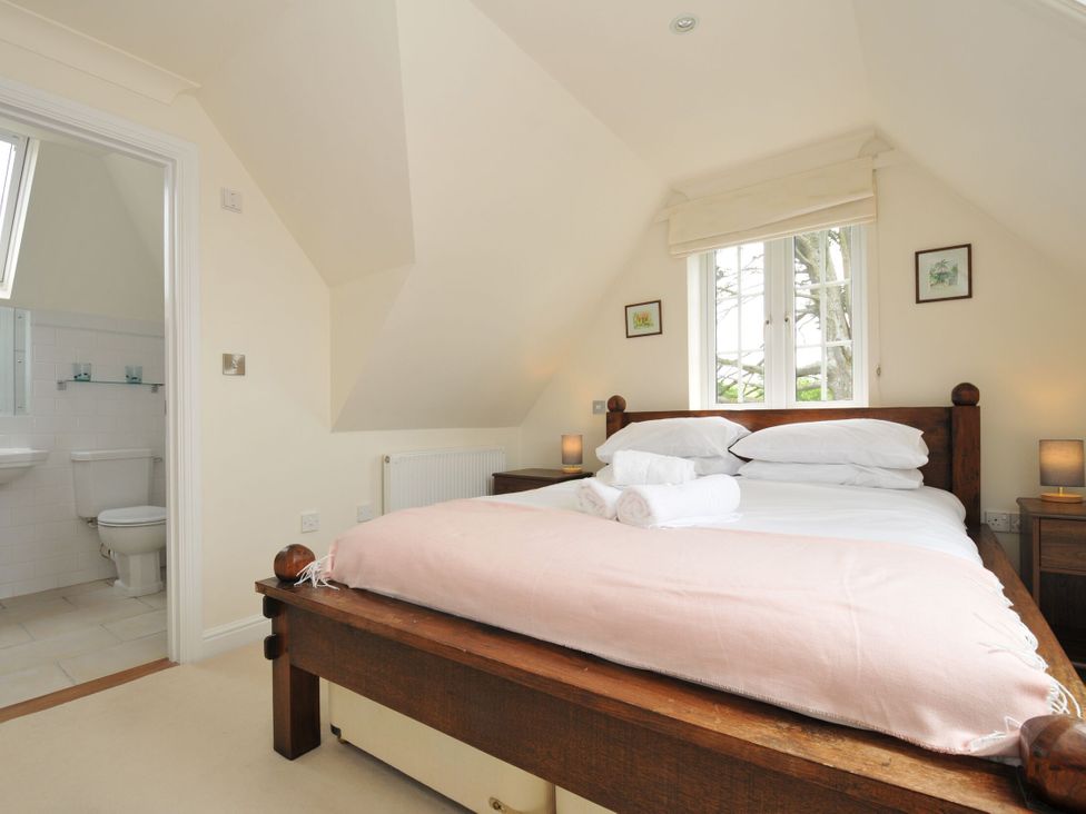 A bedroom with a bed and en-suite bathroom at Bodare 8 Daymer Bay