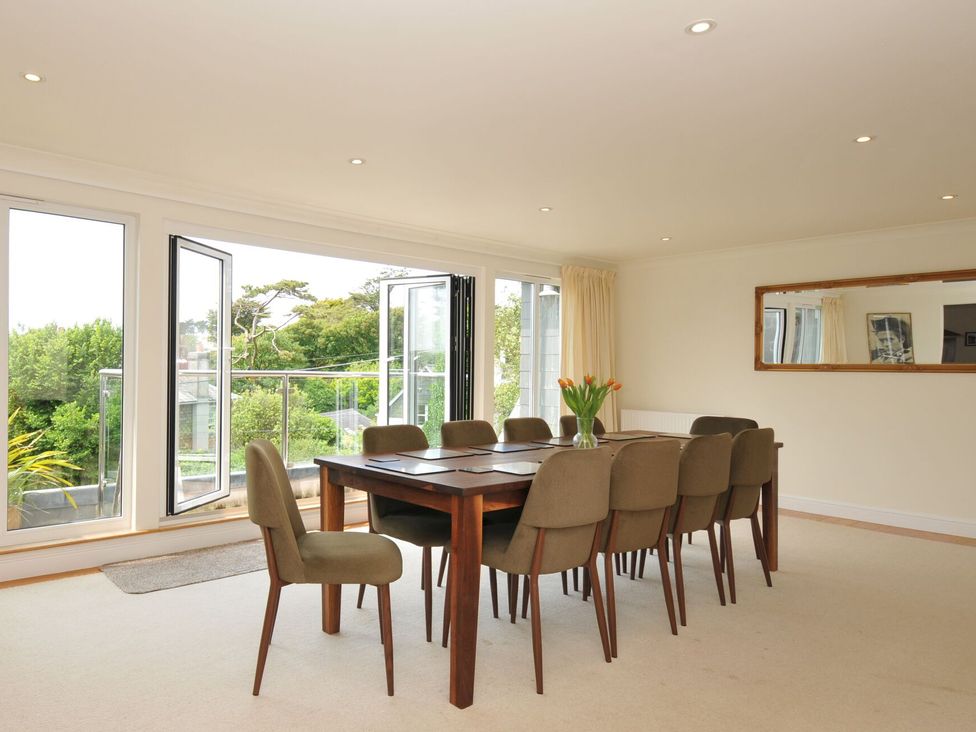 A dining room with a table and chairs at Bodare 8 in Daymer Bay