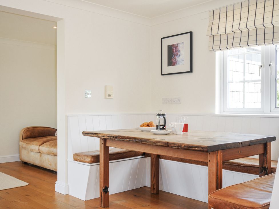 A dining area with a table and bench at Bodare 8 Daymer Bay