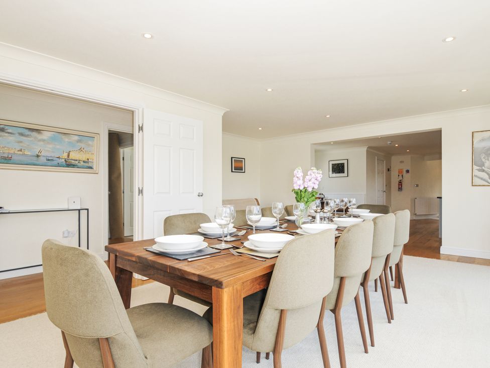 A dining room with a table set for dinner at Bodare 8 in Daymer Bay